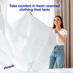 Smiling woman holding a fresh white sheet indoors with text about fresh-scented clothing and small Ensueño logo