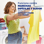 Woman in a laundry room holding up a yellow shirt with overlay text about working on difficult stains and sweat.