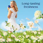 Woman in white dress smiling over a meadow graphic holding a Downy bottle with headline 'Long-lasting freshness'