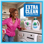 Lifestyle image showing a woman in a laundry room smiling next to Seventh Generation detergent bottle and refill pouch with 'Extra Clean' callout