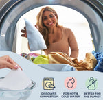 Woman loading laundry into a washing machine with an inset showing a hand holding a dissolvable detergent sheet and product icons