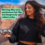 Smiling woman outdoors examining a Grind toothpaste box with a green caption warning about radiant smiles in the sky background