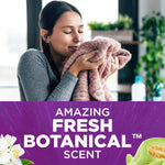 Lifestyle image of a woman smelling a sweater above a purple banner promoting 'Amazing Fresh Botanical scent'.