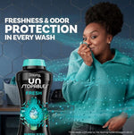 Woman holding fabric to her face next to a Downy Unstopables Fresh bottle with freshness and odor protection text