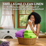 Smiling woman smelling a towel from a laundry basket of folded towels in a home laundry scene with 'Smells Like Clean Linen' text