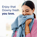 Woman hugging a soft blue towel next to text reading ‘Enjoy that Downy fresh you love.’