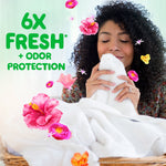 Woman smelling a freshly laundered towel with floating hibiscus flowers and '6X FRESH + ODOR PROTECTION' text
