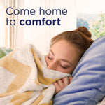 Woman smelling a cozy blanket with text 'Come home to comfort' suggesting the Downy Blends Toasted Vanilla scent experience