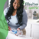 Woman using a blue dishwand to clean a glass bottle in a bright kitchen with 'Effective + Gentle' text overlay.