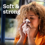 Woman pressing a tissue to her nose with overlay copy 'Soft & strong', promotional lifestyle image for Kleenex tissues.