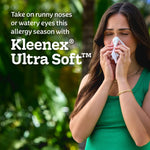 Woman holding a Kleenex tissue to her nose outdoors with text promoting Kleenex Ultra Soft for allergy season
