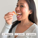 Woman using an orange PUL removal tool to remove a clear aligner from her teeth, certification icons along bottom.