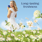 Woman in a white dress holding a Downy Folia bottle in a flowery meadow with headline text ‘Long-lasting freshness’