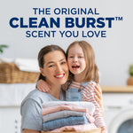 Smiling woman holding folded laundry with headline The Original Clean Burst Scent You Love above in a lifestyle laundry scene