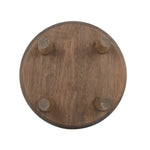 Underside view of a round wooden plant stand showing four attached cylindrical legs and wood grain