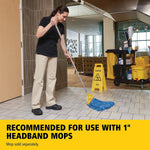 Worker mopping tiled floor with a gray handle and yellow Invader mop head beside a cleaning cart and caution sign