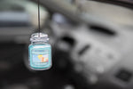 Hanging Yankee Candle Bahama Breeze Car Jar air freshener suspended inside a blurred car interior