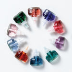 Circular arrangement of multiple colorful ScentPlug refill bottles laid out on a white surface.