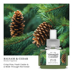 Yankee Candle Balsam & Cedar ScentPlug refill bottle in front of a close-up pine branch and pinecone background with scent description text.