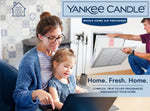 Lifestyle image showing a smiling woman and child with a man installing a furnace filter, Yankee Candle branding and slogan Home. Fresh. Home.