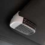 Yankee Candle Sidekick visor clip clipped to a vehicle visor, angled view of decorative grille