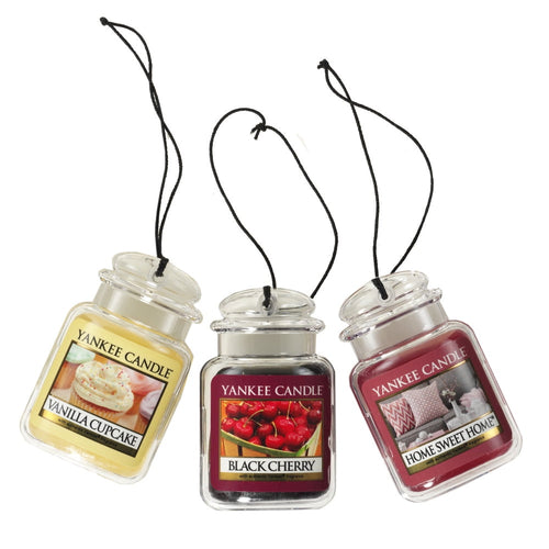 Three Yankee Candle hanging car-jar air fresheners (Vanilla Cupcake, Black Cherry, Home Sweet Home) shown with black cords.