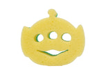 Yellow sponge shaped like an alien with three eye holes and a smiling mouth, showing green scrubby edge