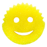 Close-up of a yellow Scrub Daddy smiley scrub pad on white background showing textured scrub surface