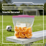 Clear Ziploc bag with pink zipper holding orange wedges on a bench at a soccer field with the text 'Snacks Secured'.