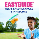 Outdoor lifestyle shot of a child tossing a clear Ziploc snack bag with green EasyGuide zipper and orange snacks