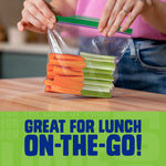 Hands sealing a Ziploc sandwich bag filled with cut vegetables on a kitchen counter, with 'Great for lunch on-the-go' text below.