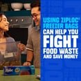 Promotional lifestyle image showing two people in a kitchen with Ziploc Freezer graphics about reducing food waste