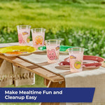 Outdoor picnic scene with several clear Zoo Pals cups and matching themed paper plates on a wooden table.